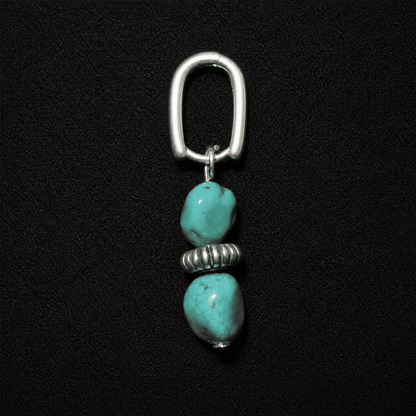 Artisan heritage style S925 silver hoop earrings featuring raw turquoise nuggets, displayed on a textured neutral fabric