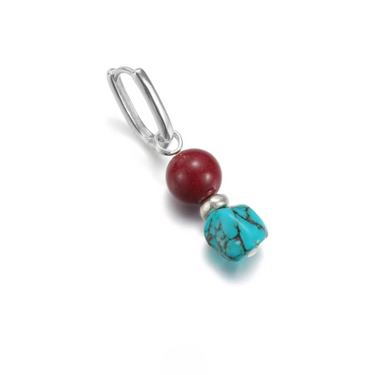 Silver hoop earring with a red cinnabar bead and a raw turquoise bead.