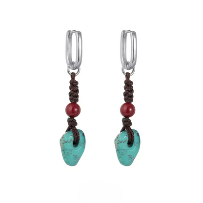 Two silver hoop studs with brown knotted cord, red beads, and turquoise stones.