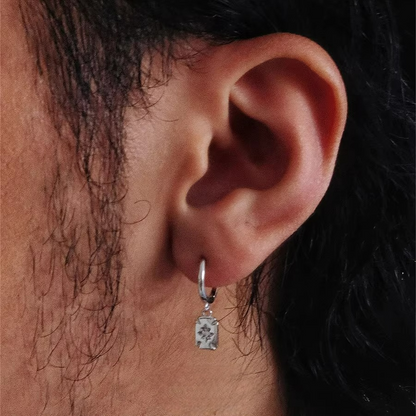 Silver huggie earring with a rectangular drop charm featuring a star design.