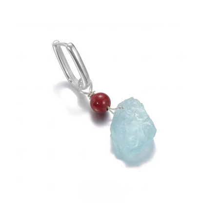 Silver dangle earring with a red bead and raw light blue stone.