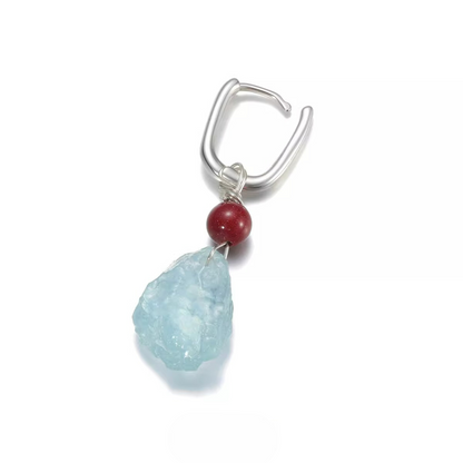 Silver ear cuff with a red bead and raw aquamarine stone dangle.