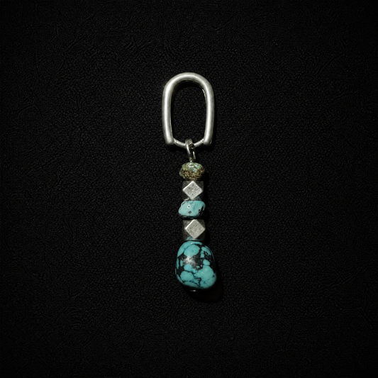 Model wearing a tribal boho S925 silver hoop earring featuring a chunky raw ore turquoise dangle