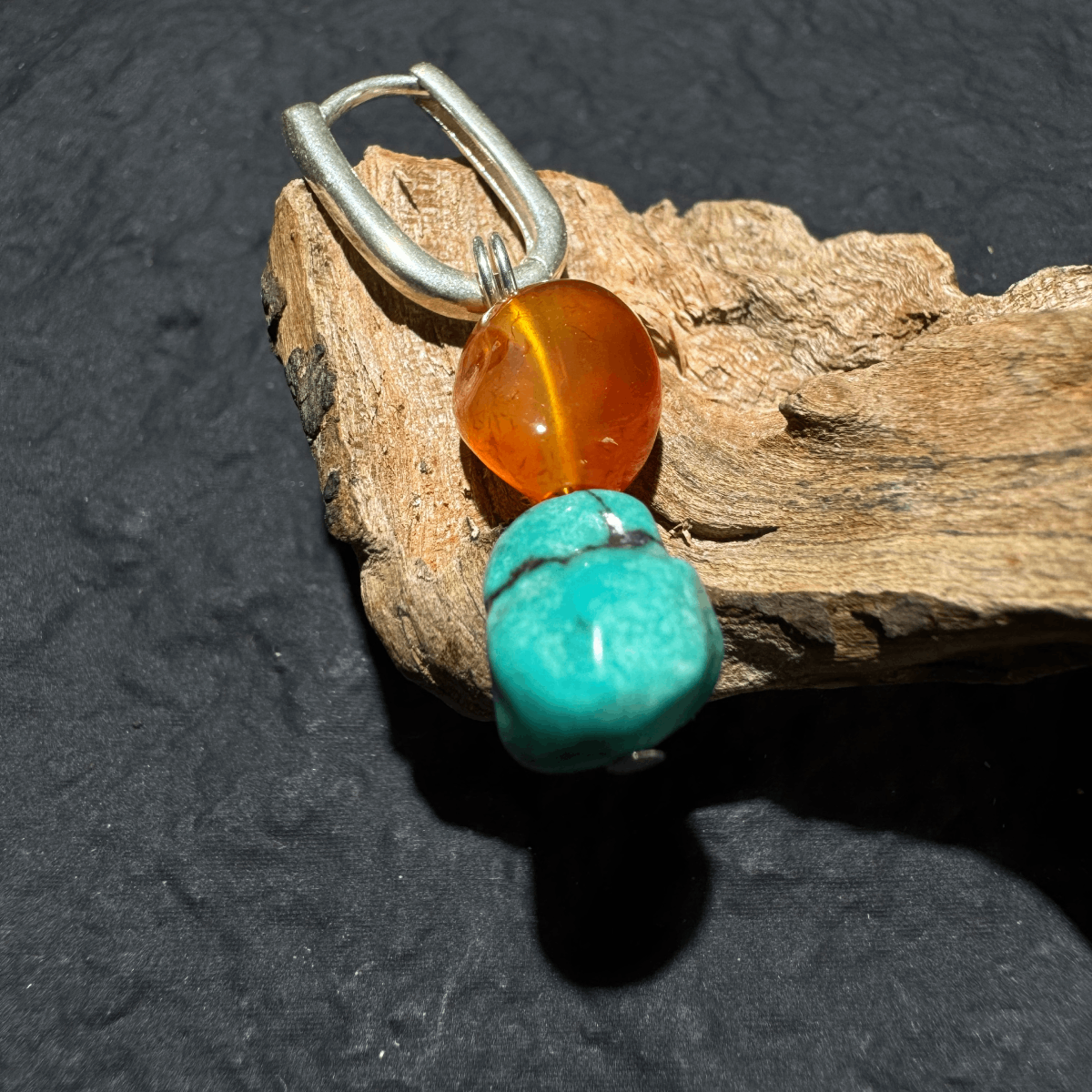 S925 silver hoop earrings featuring irregular raw turquoise nuggets and red agate beads, isolated on a textured grey surface.